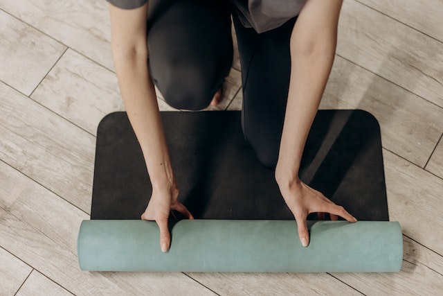 A person is holding onto a yoga mat