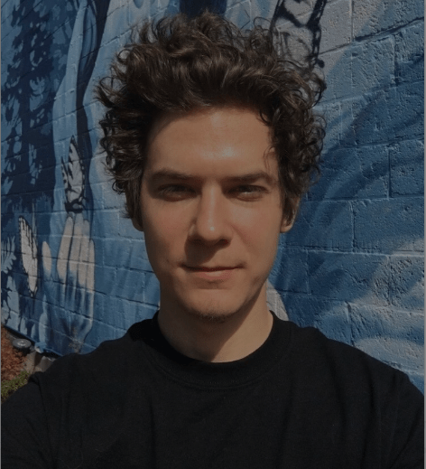 A man with curly hair and black shirt.