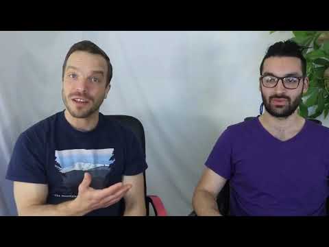 Two men sitting in front of a white wall.