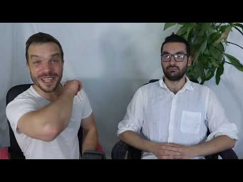 Two men in white shirts and glasses are sitting.