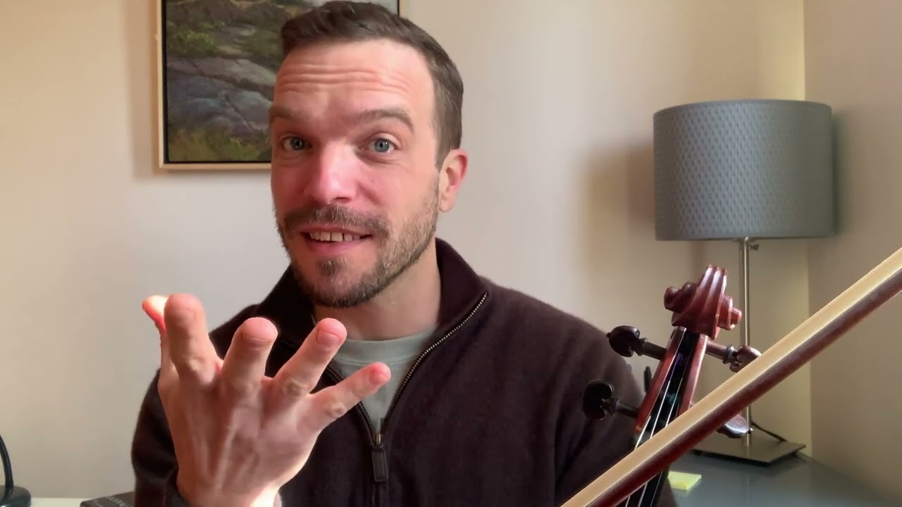 A man holding his hand up to the side of his face.