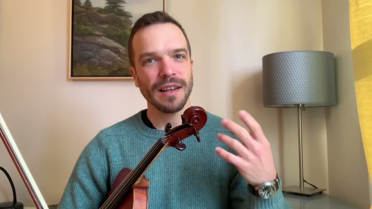 A man holding a violin in his hand.