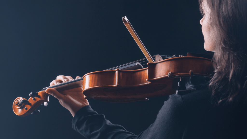 A person holding a violin in their hands.