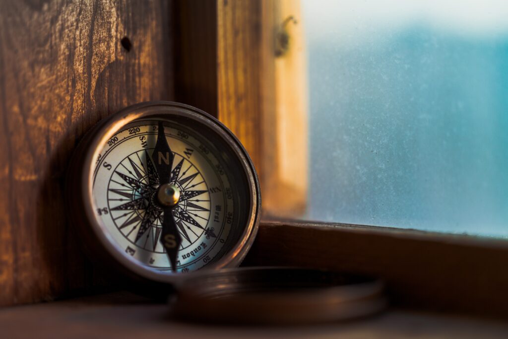 A compass sitting on top of a wooden table.