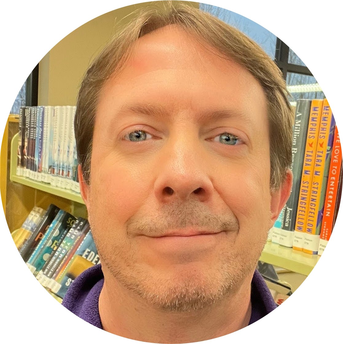 Headshot of a man in a library.