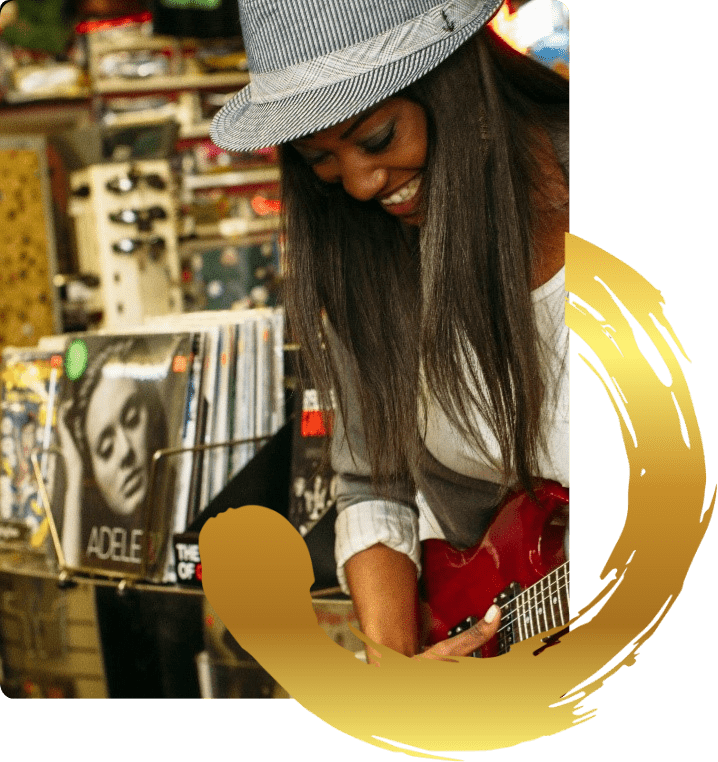 Smiling woman playing a red guitar.